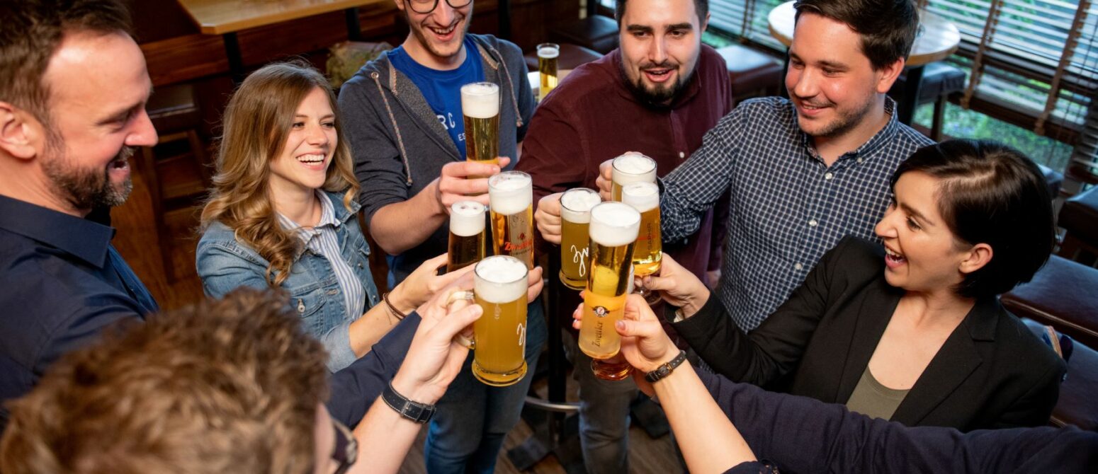 Besuchergruppe beim Anstoßen mit Bier